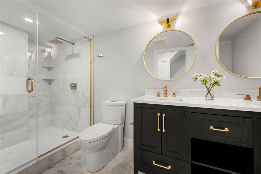 67 Revere Street, Unit 1 Boston, MA 02114 - Photo 13 of 29 a bathroom with a toilet a sink a light fixture and a mirror