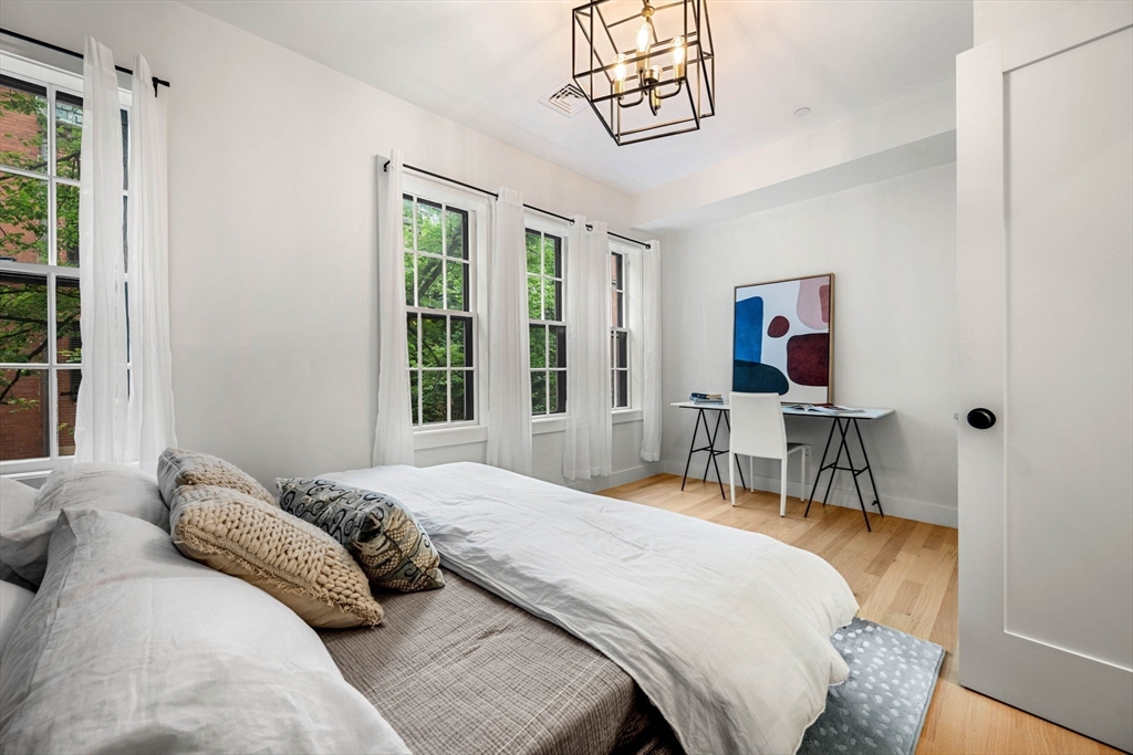 67 Revere Street, Unit 1 Boston, MA 02114 - Photo 20 of 29 a bedroom with a bed and a table in it