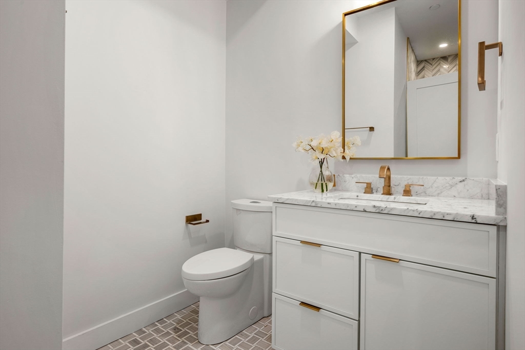 67 Revere Street, Unit 1 Boston, MA 02114 - Photo 21 of 29 a bathroom with a granite countertop toilet sink and mirror