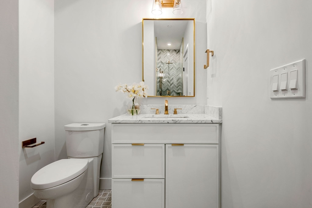 67 Revere Street, Unit 1 Boston, MA 02114 - Photo 23 of 29 a bathroom with a toilet sink and mirror
