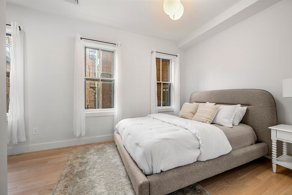 67 Revere Street, Unit 1 Boston, MA 02114 - Photo 26 of 29 a bedroom with a bed lamp and a window
