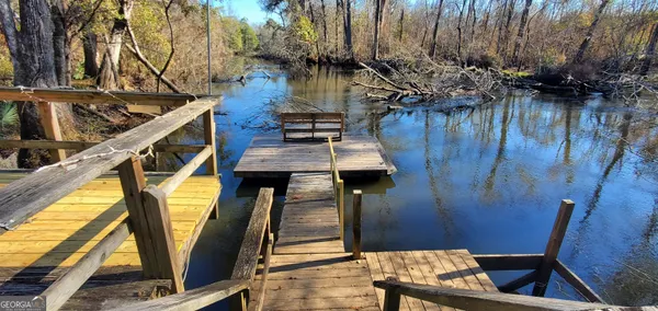 a view of outdoor space with wooden deck and lake view