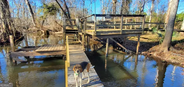 a view of swimming pool with a yard and wooden fence