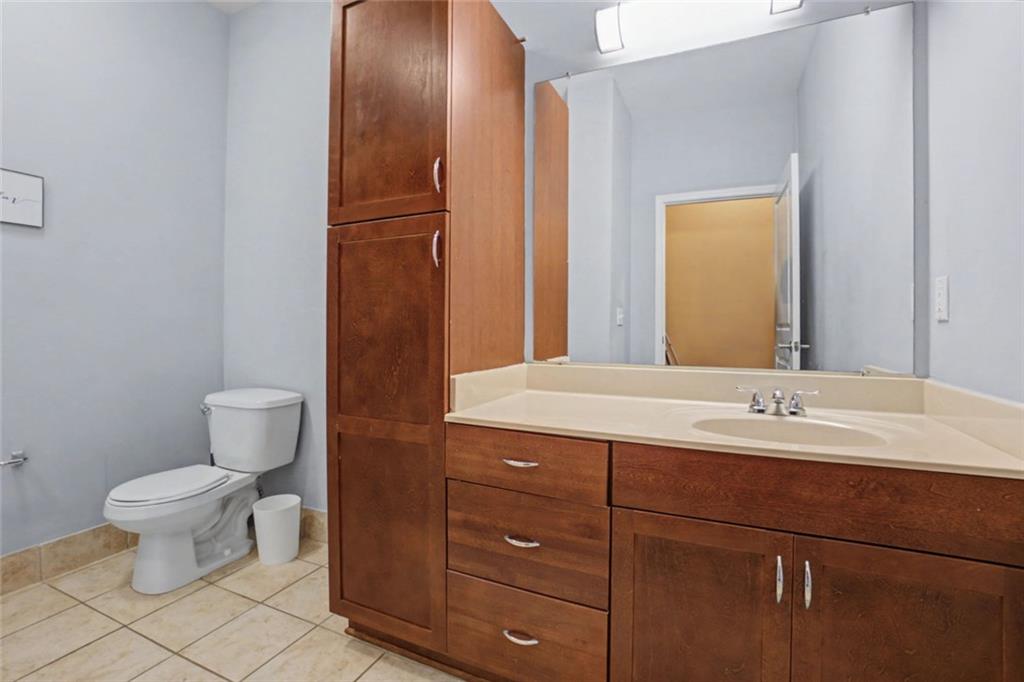 870 Mayson Turner Road Northwest, Unit 1311 Atlanta, GA 30314 - Photo 8 of 29 a bathroom with a granite countertop toilet sink and mirror