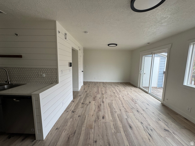 608 South 500 West, Unit 3 Provo, UT 84601 - Photo 8 of 35 Open-concept living area featuring wood-finish flooring, white shiplap accent wall, white hexagonal tile backsplash, a sliding glass door, and flush-mount lighting fixtures