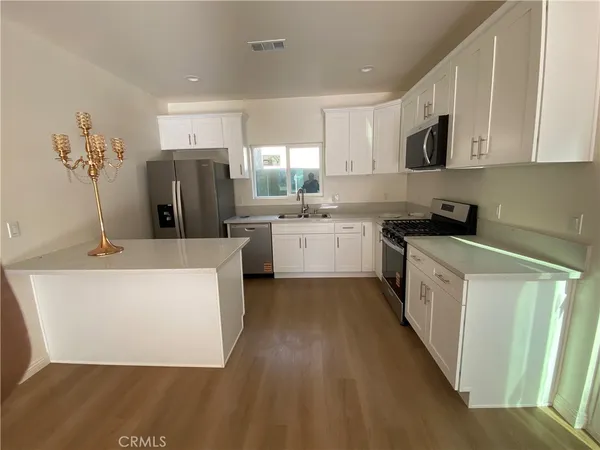 a kitchen with a sink a refrigerator and cabinets
