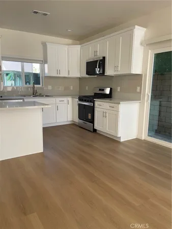 a kitchen with granite countertop white cabinets and appliances