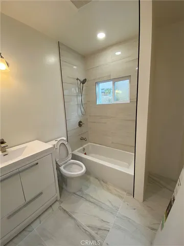 a bathroom with a granite countertop sink toilet and bathtub