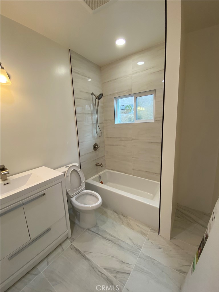 18543 Ingomar Street Reseda, CA 91335 - Photo 6 of 10 a bathroom with a granite countertop sink toilet and bathtub