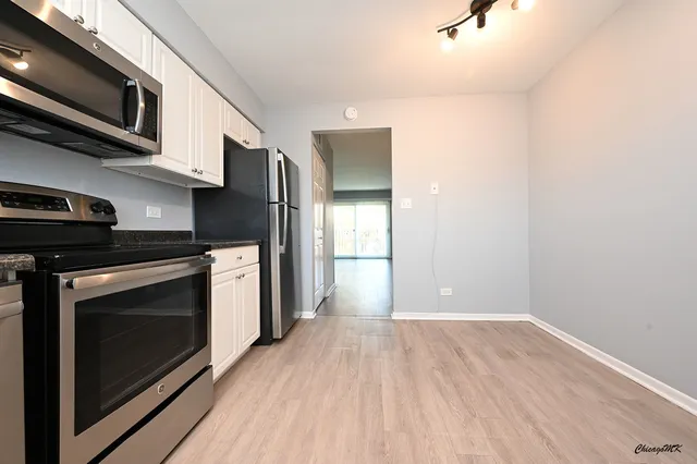 a view of a kitchen with a stove a microwave and cabinets
