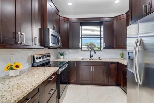 a kitchen with stainless steel appliances granite countertop a sink stove and refrigerator
