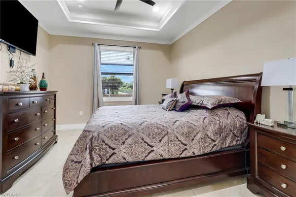 a bedroom with a large bed and flat tv screen on dresser