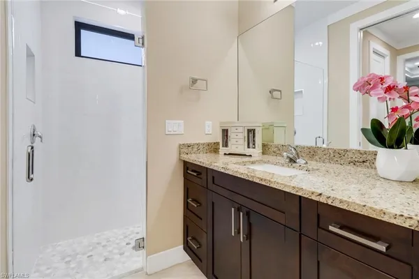 a bathroom with a granite countertop sink and a mirror
