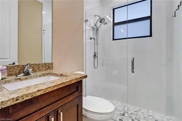 a bathroom with a granite countertop sink toilet and shower