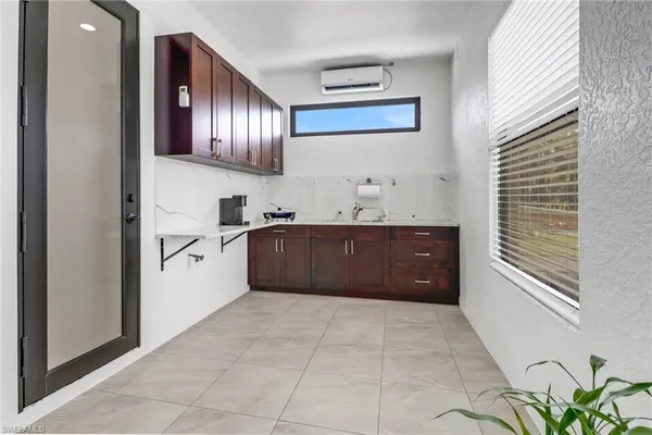 a spacious bathroom with a granite countertop sink a mirror and bathtub