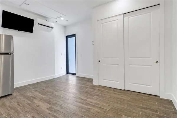 a view of an empty room with wooden floor