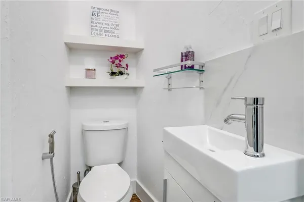 a bathroom with a sink mirror and toilet
