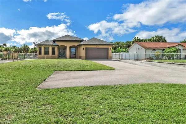 a front view of a house with a garden and yard