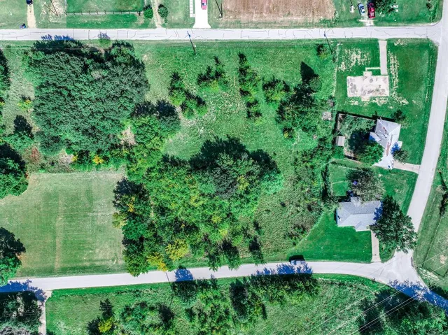 an aerial view of residential house with outdoor space and trees all around
