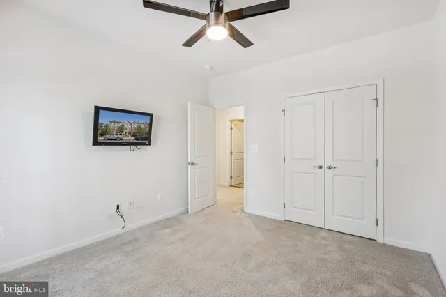 a view of a livingroom with a ceiling fan & entryway