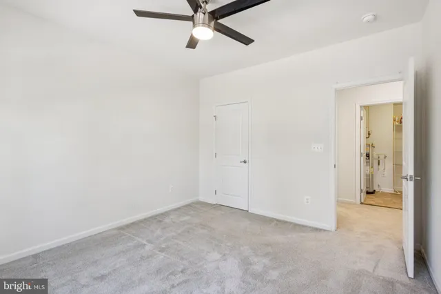 an empty room with a ceiling fan and a window
