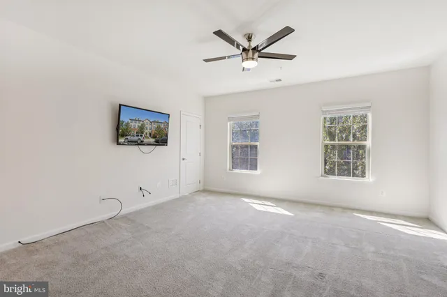 a view of a livingroom with a ceiling fan and window