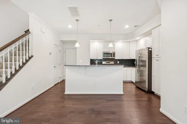 a view of kitchen with stainless steel appliances refrigerator oven microwave and cabinets