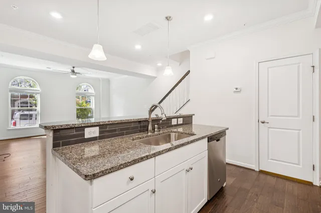 a kitchen with granite countertop kitchen island a sink and a wooden floors