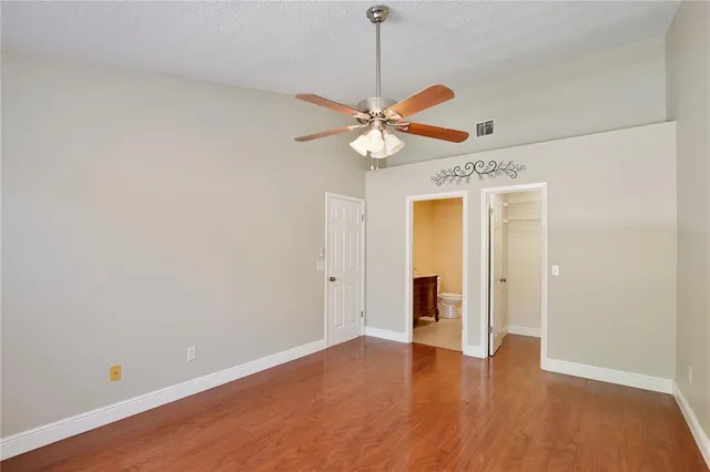 a view of a kitchen with wooden floor and a ceiling fan