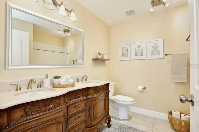 a bathroom with a granite countertop toilet sink and mirror
