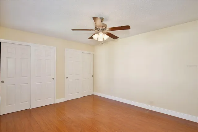 a view of an empty room and chandelier fan