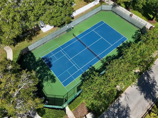 a green field with lots of plants and trees in front of it