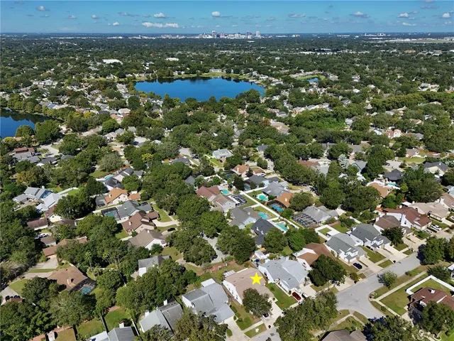 an aerial view of residential houses with outdoor space and trees