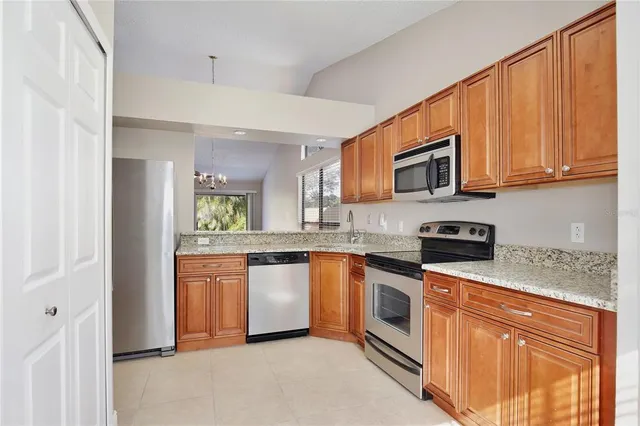 a kitchen with stainless steel appliances granite countertop a refrigerator a stove top oven a sink and dishwasher
