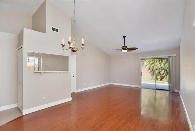 a view of an empty room with window and wooden floor