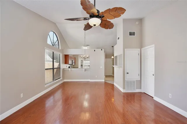 a view of an empty room with window and wooden floor
