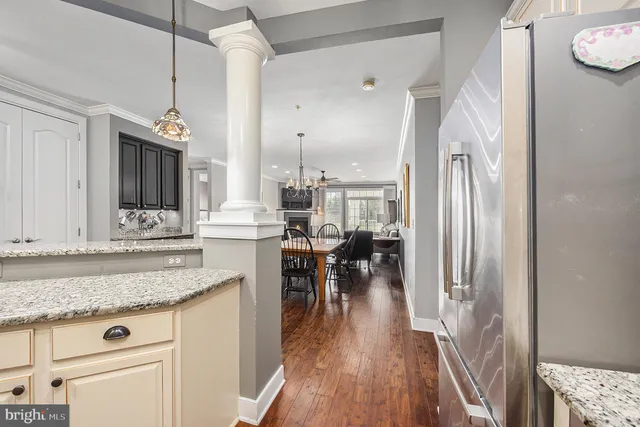 a kitchen with stainless steel appliances granite countertop a refrigerator a stove and a wooden floors