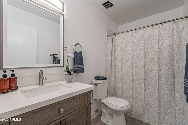 a bathroom with a sink a toilet and a mirror