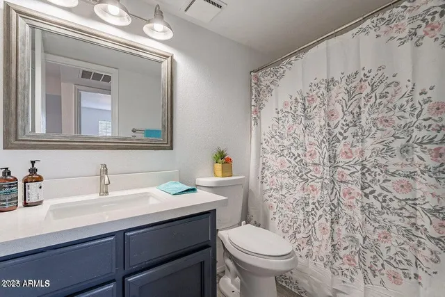 a bathroom with a sink a toilet and a mirror