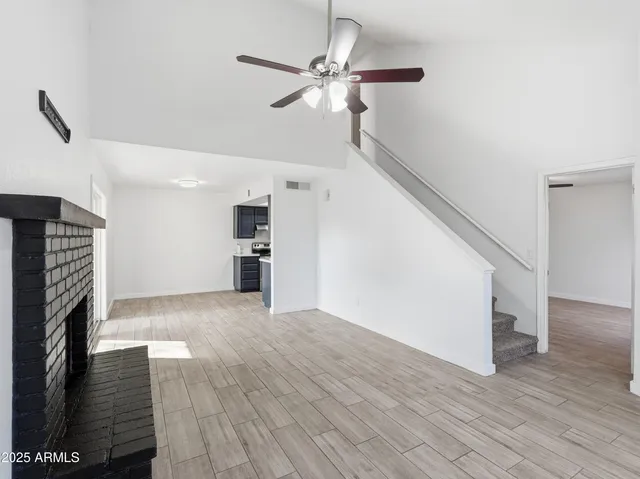 a view of empty room with wooden floor and fireplace