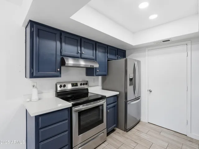 a kitchen with stainless steel appliances a stove a refrigerator and cabinets