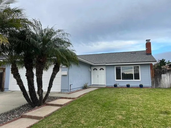 a view of a house with backyard and a tree