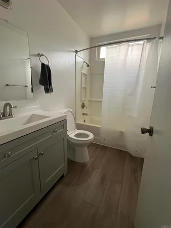 a bathroom with a granite countertop sink a toilet a shower and a mirror