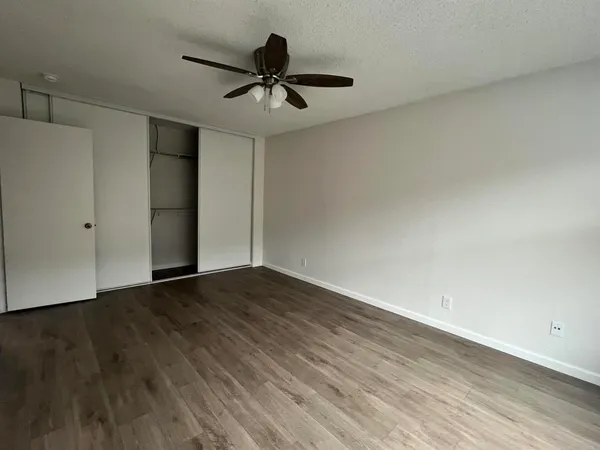 a view of empty room with wooden floor