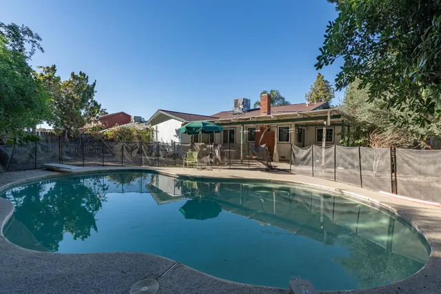a view of a house with swimming pool next to a yard