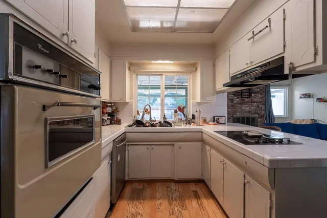 a kitchen with a sink stainless steel appliances and cabinets