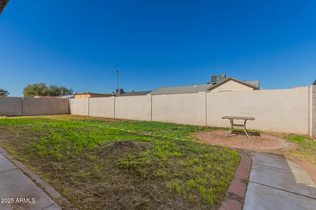 a view of a backyard with table and chairs and wooden fence