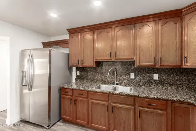 a kitchen with stainless steel appliances granite countertop a refrigerator and cabinets