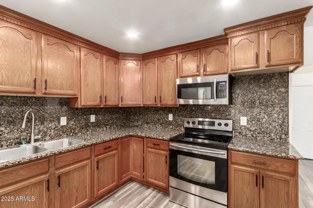 a kitchen with granite countertop cabinets stainless steel appliances and a counter space