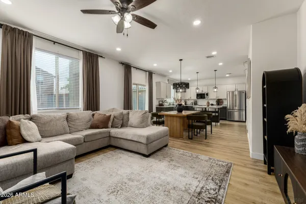 a living room with furniture kitchen view and a large window